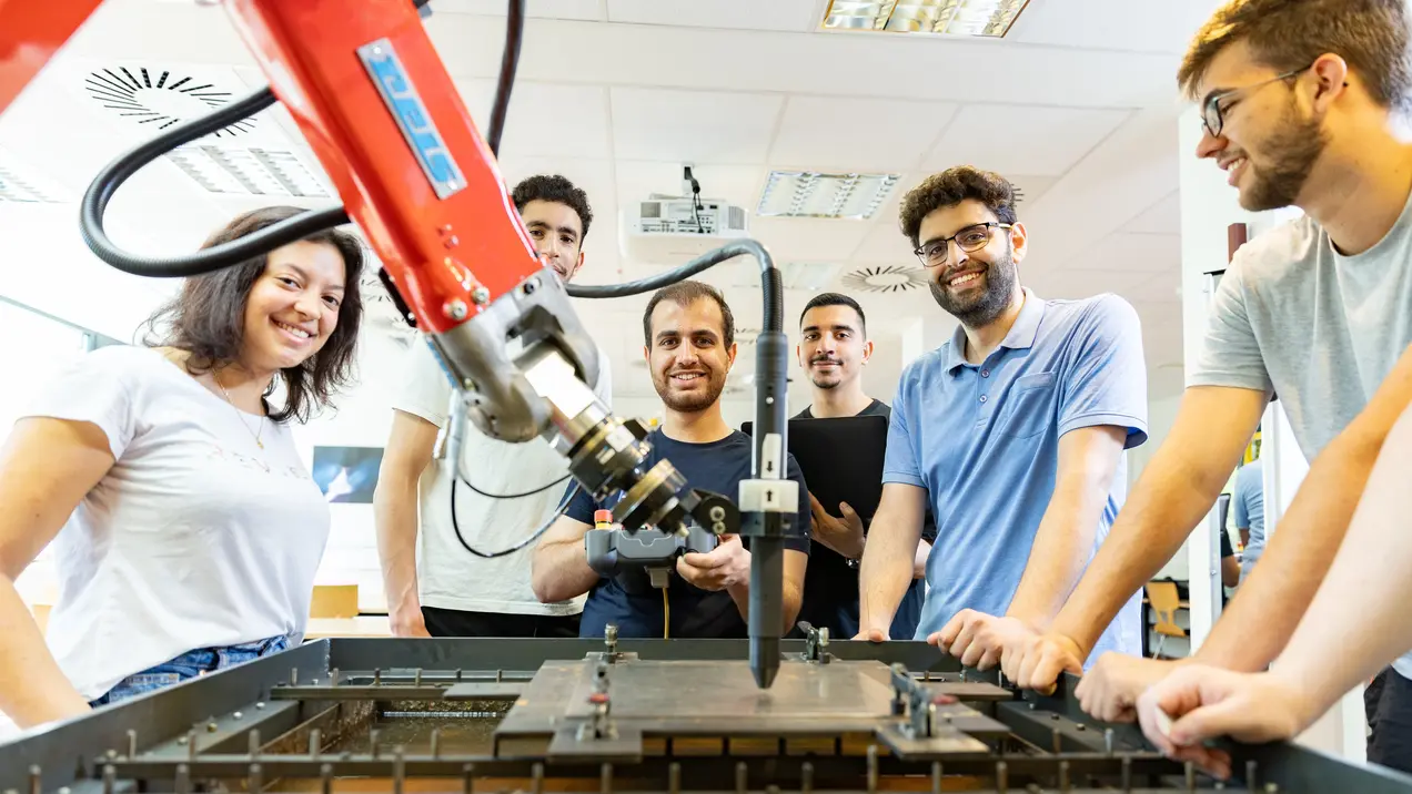ING Studierendengruppe Roboter eine Gruppe von Studierenden bedient einen Roboter im Labor