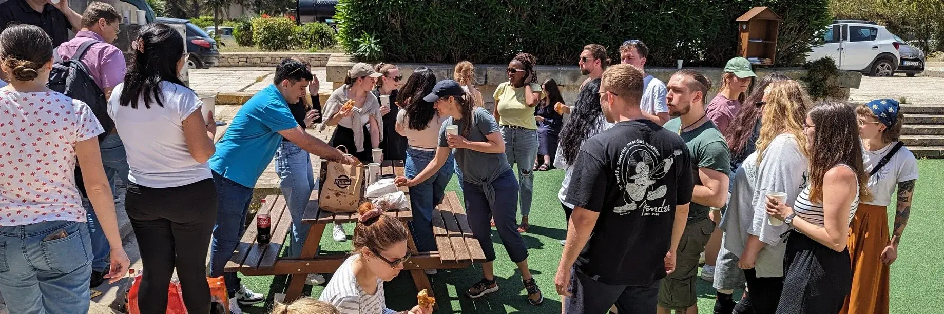 Maltesische und deutsche Studierende beim Kennenlernen mit maltesischen Snacks und "Kinnie" (maltesisches Erfrischungsgetränk) 