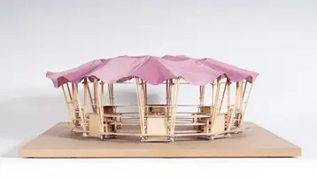 The picture shows the wooden architectural model by Katharina Schön and Daniel Krönung on the theme of ‘Amphitheatre – Lißberg open-air stage’. It is a light-looking central structure with red fabric as the roof covering.