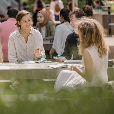 Studierende an einem Tisch auf dem Campus