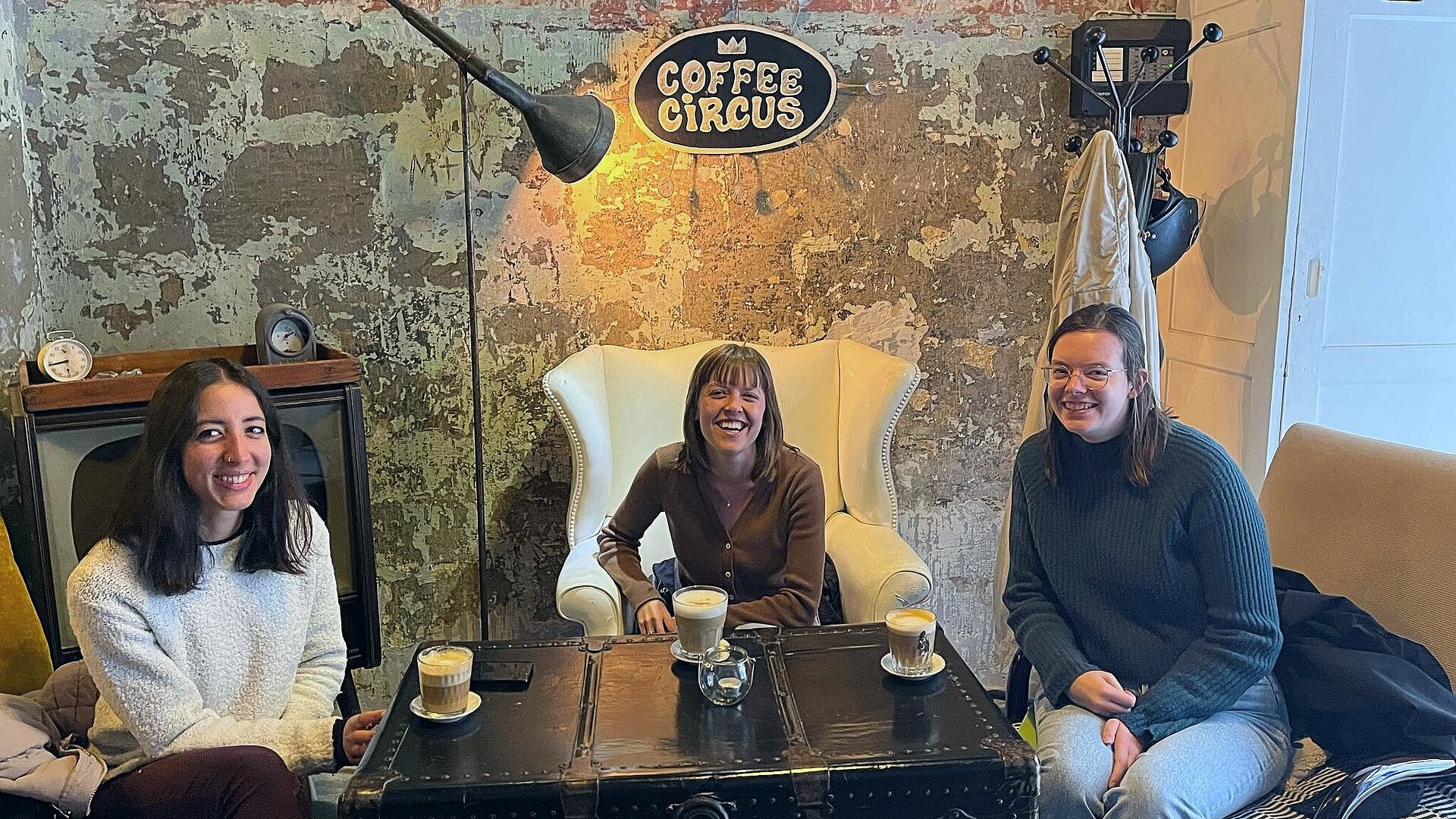 Eva Lützeler sitzt mit zwei Freundinnen im Café Coffee Circus, auf dem Tisch vor ihnen stehen Getränke