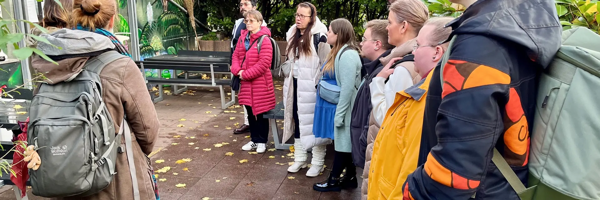 Personen stehen im Freien und hören gespant zu 
