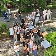 Schüler:innen im Innenhof der Wiesbaden Business School im Gespräch mit aktuellen Studierenden.