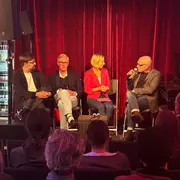 Prof. Daniel Seiberts, Prof. Georg Ebbing, Moderatorin Prof. Dr. Jessica Einspänner-Pflock, und Prof. Volker Kleinekort auf dem Podium bei HSRM-Dialog im ZR6