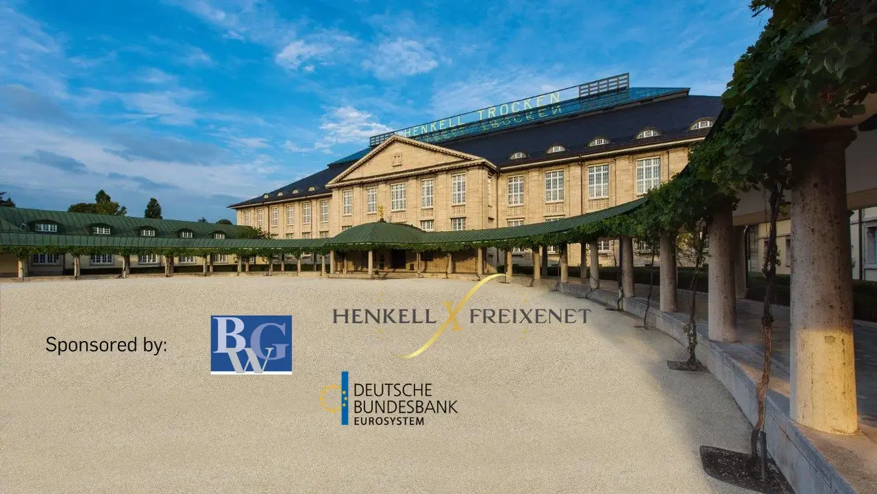 Eine grandiose Architektur mit einer großen, hellen Fassade und vielen Fenstern ist abgebildet. Im Vordergrund ist ein weitläufiger Platz zu sehen. Logos der Sponsoren "BGW" und "Deutsche Bundesbank" sind prominent platziert, was auf eine Veranstaltung hinweist.