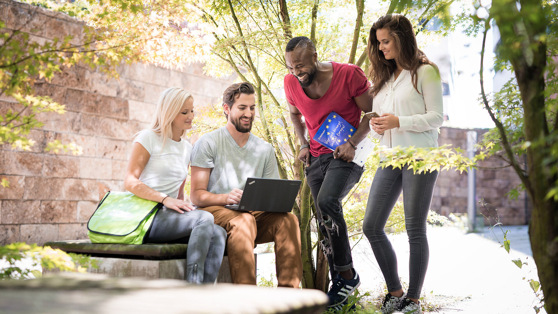 Symbolfoto Doktorandenmobilität Gruppe junger Menschen im Freien mit Erasmus-Block