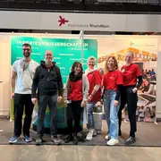 Sechs Vertreter der Hochschule RheinMain stehen am Messestand auf der Stuzubi 2026 in Mainz. 