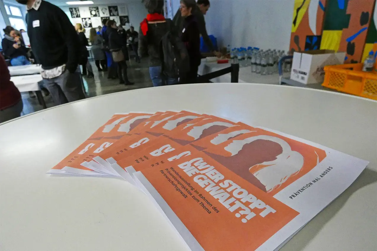 Auf einem Tisch liegen Flyer der Wanderausstellung „(W)er stoppt die Gewalt?!“.