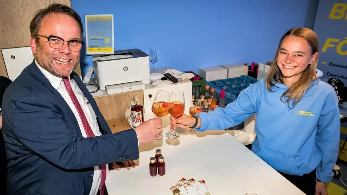 Staatsminister Timon Gremmels schüttelt einer Gründerin die Hand