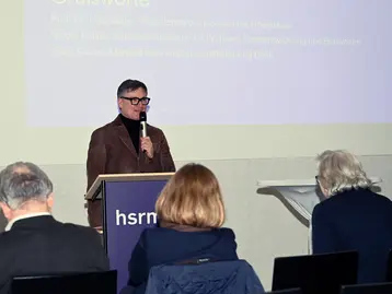 Prof. Dr. Bernd Wieberneit von der Hochschule RheinMain begrüßt die Gäste beim 2. Wiesbadener Tag für sozial nachhaltiges Investieren.