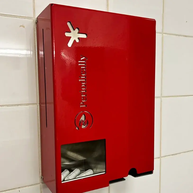 Tampons und Bindenspender Foto eines roten Tampon- und Binden Spenders mit Hochschullogo