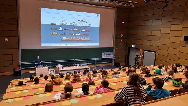 Simon Beckmann hält Vorlesung vor mehr als 80 Kindern.
