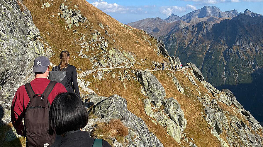 Natalie Hermann Drei Menschen besteigen einen Berg