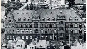 Das Bild zeigt das Ingenieurbaugebäude, ein historisches Gebäude, das seit 1910 besteht. Die Ansicht ist von oben, wobei die markanten Türme und Fenster des Gebäudes hervorgehoben werden. Die Umgebung ist teilweise sichtbar, jedoch steht das Ingenieurbaugebäude im Mittelpunkt.