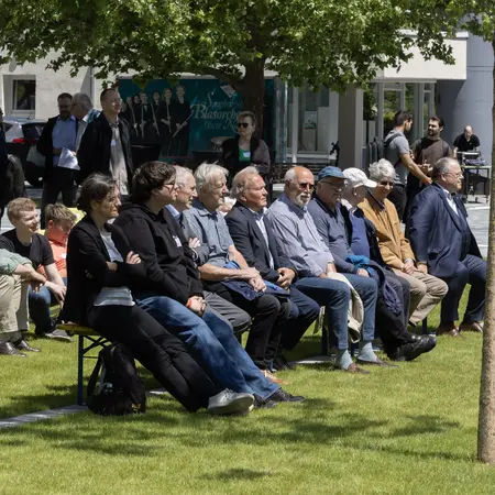 Bei Sonnenschein verfolgten die Besucher:innen die Podiumsdiskussion.