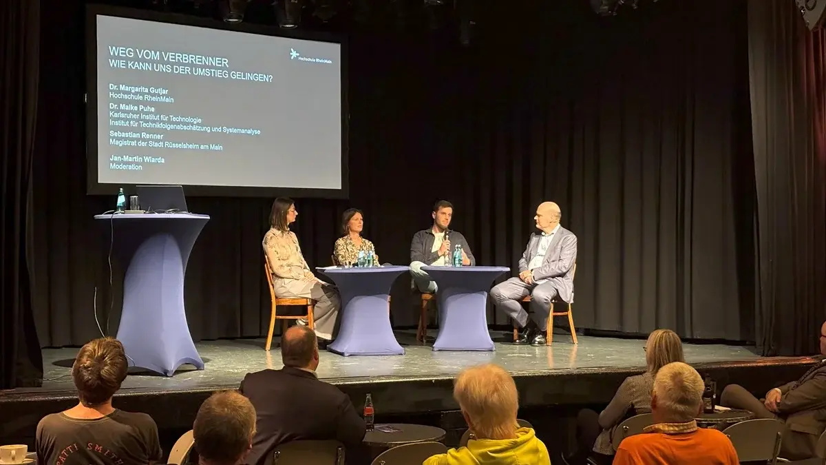 Expert:innen und Moderator auf der der Bühne des Kulturzentrums Das Rind bei der Veranstaltung HSRM-Dialog zum Thema "Weg vom Verbrenner – wie gelingt der Umstieg?"