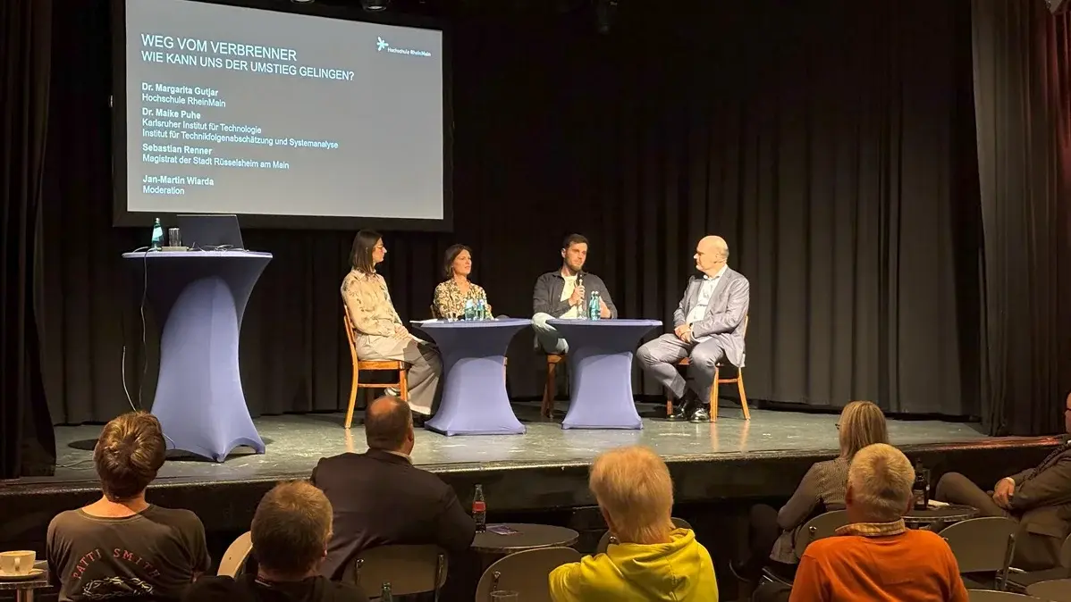 Expert:innen und Moderator auf der der Bühne des Kulturzentrums Das Rind bei der Veranstaltung HSRM-Dialog zum Thema "Weg vom Verbrenner – wie gelingt der Umstieg?"