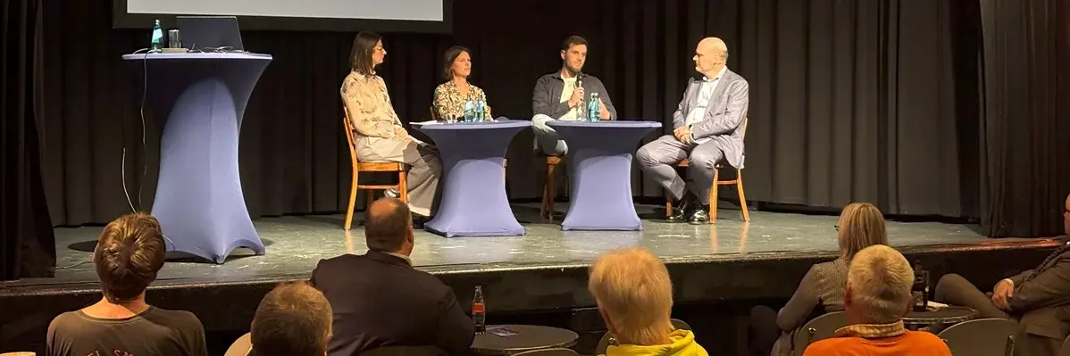 Expert:innen und Moderator auf der der Bühne des Kulturzentrums Das Rind bei der Veranstaltung HSRM-Dialog zum Thema "Weg vom Verbrenner – wie gelingt der Umstieg?"