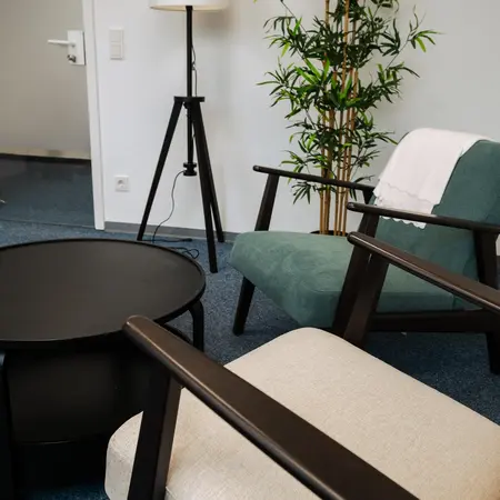 Zwei Sessel mit Tisch, Lampe und Pflanze im Raum