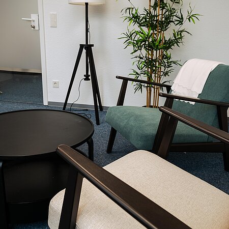 Beratungsraum BL3 Zwei Sessel mit Tisch, Lampe und Pflanze im Raum