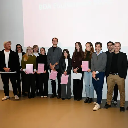 Gruppenbild der Jurymitglieder und Preisträgerinnen und Preisträger des BDA Studienpreis 2025. Im Hintergrund ist eine Präsentation mit dem Text „BDA Studienpreis 2023“ zu sehen. Die Anwesenden lächeln und posieren für das Foto.