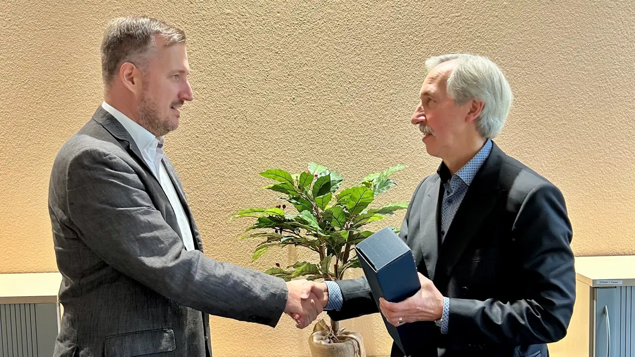 Dekan Prof. Dr. Till Dannewald überreicht Prof. Dr. Jürgen Reim sein Abschiedsgeschenk. 