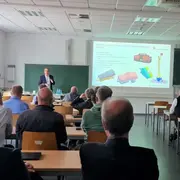 Prof. Dr. Christian Glockner hält einen Fachvortrag in einem vollen Seminarraum.