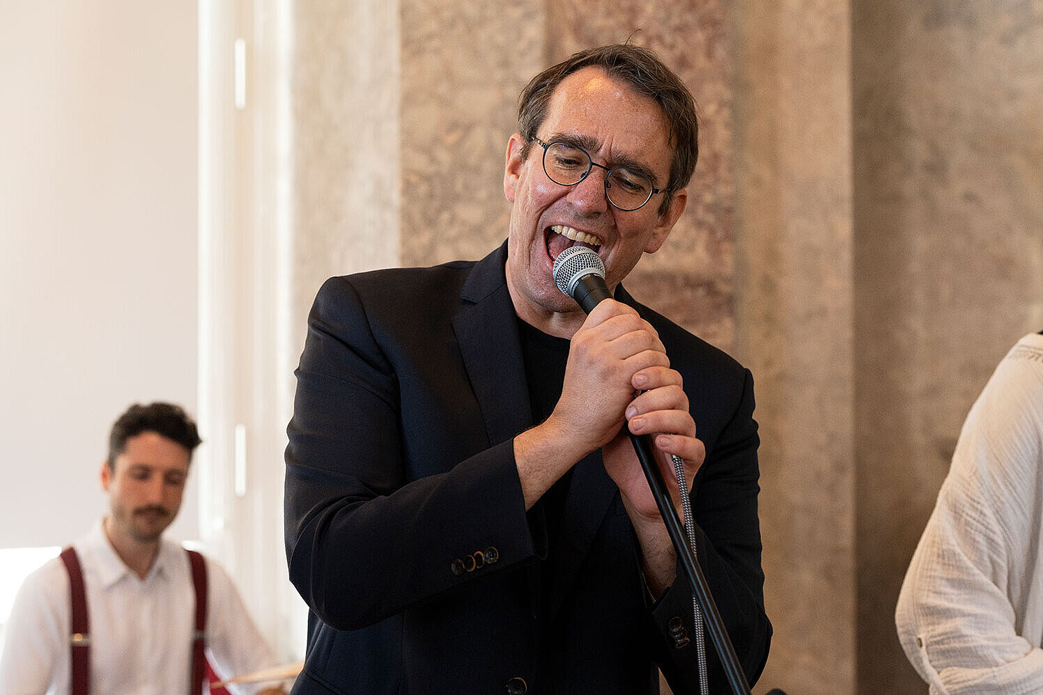 Prof. Dr. Adrian Ulges singt in ein Mikrofon.