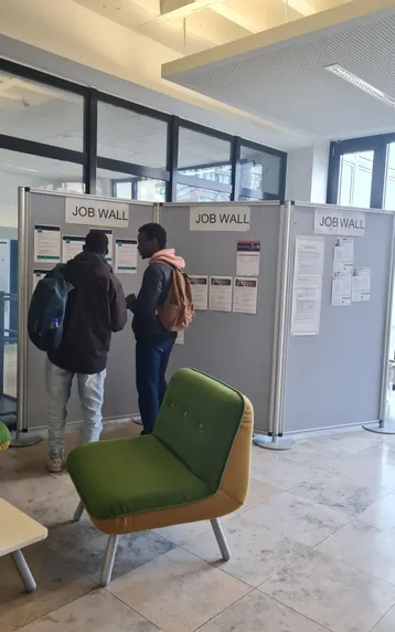 Studierende lesen die Stellenangebote an der Jobwall