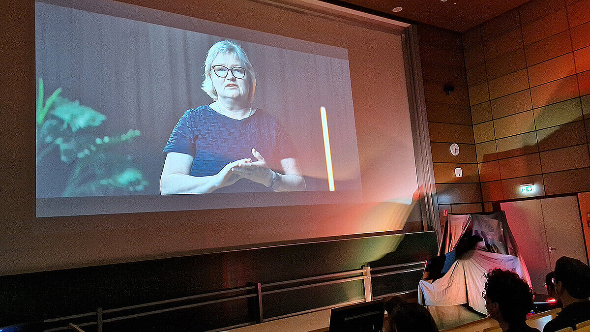 Auf einer Leinwand ist Hochschulpräsidentin Prof. Dr. Eva Waller zu sehen