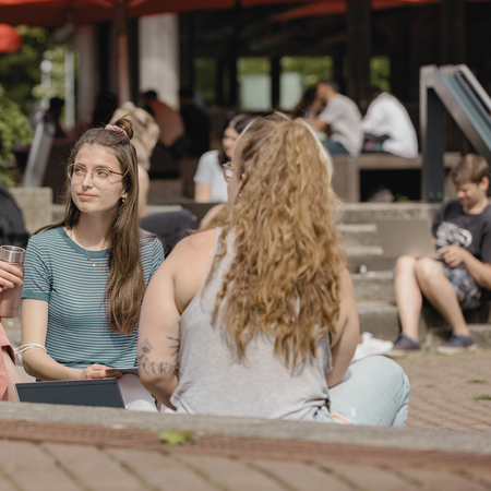 Studierende in einem Kreis auf dem Campus
