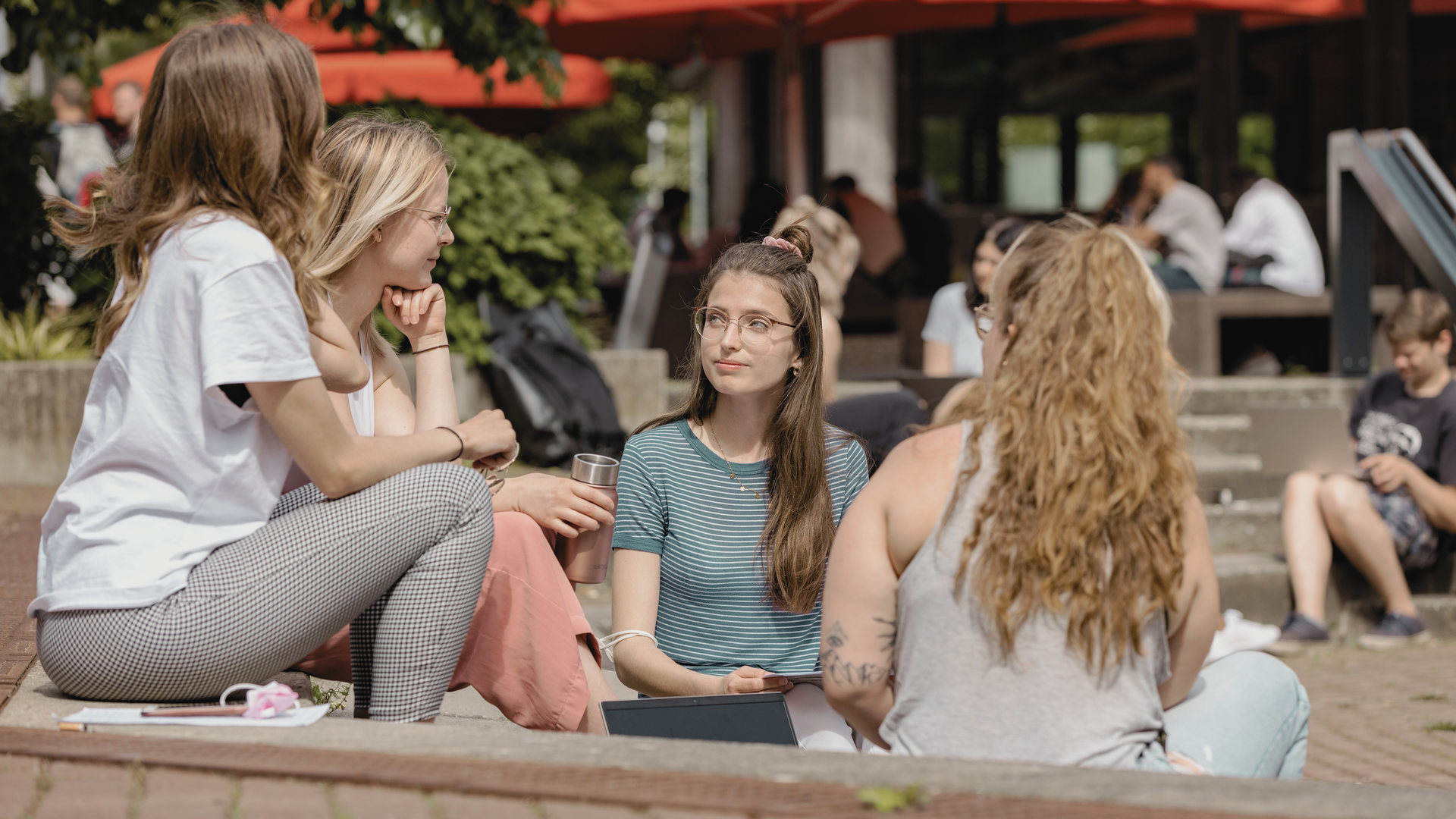 Studierende in einem Kreis auf dem Campus