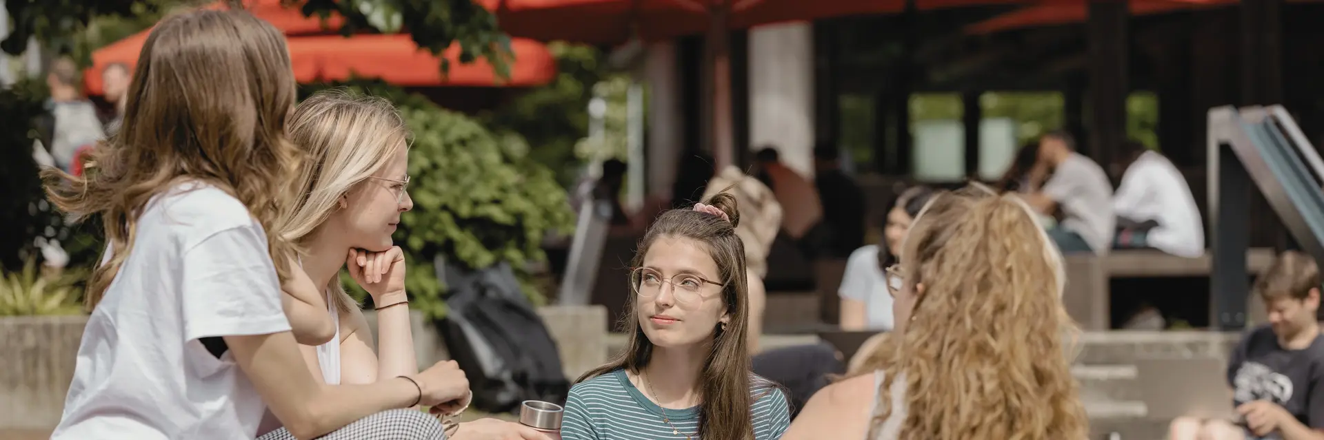 Studierende in einem Kreis auf dem Campus