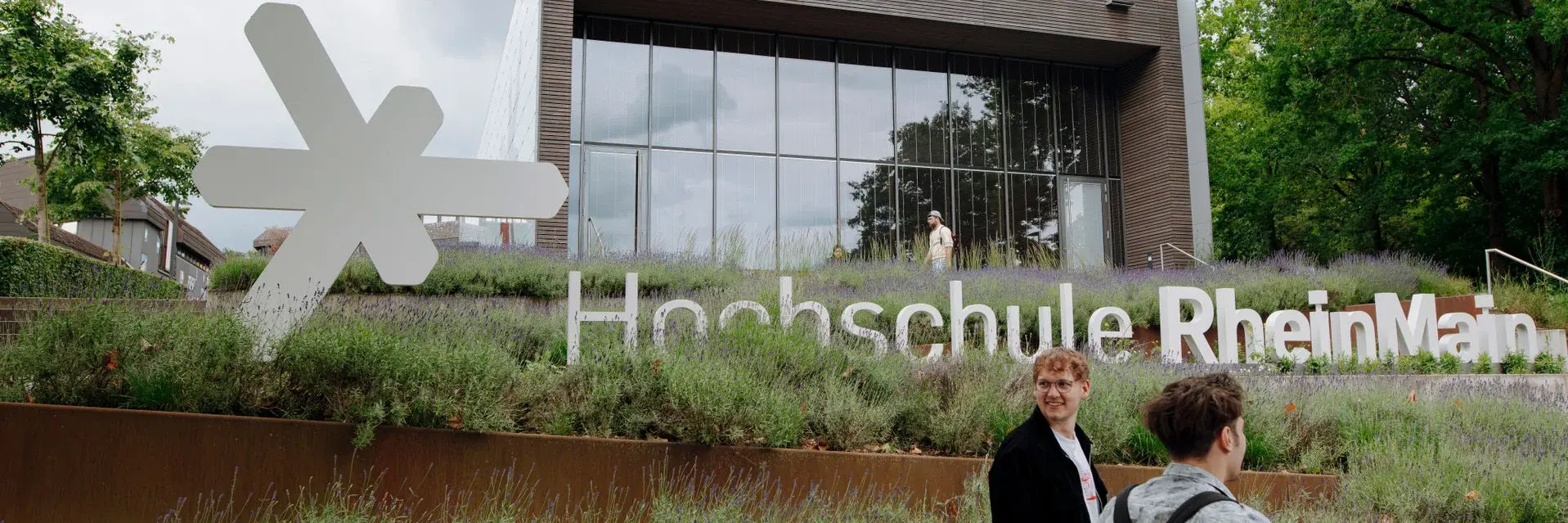 Studenten vor dem Schriftzug Hochschule RheinMain
