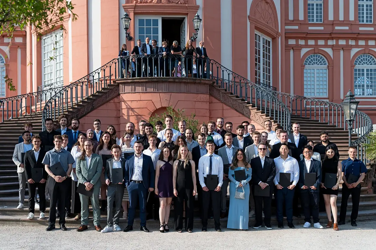 Die Absolvent:innen der Informatik-Studiengänge stehen für ein Gruppenfoto vor dem Schloss Biebrich.