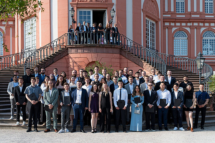 Die Absolvent:innen der Informatik-Studiengänge stehen für ein Gruppenfoto vor dem Schloss Biebrich.