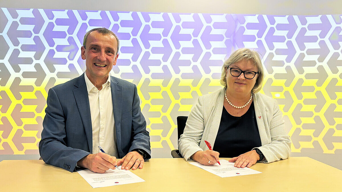 Prof. Dr. Eva Waller, Präsidentin der HSRM, und Prof. Dr. Rainer Petzina, Rektor der MSH sitzen an einem Tisch