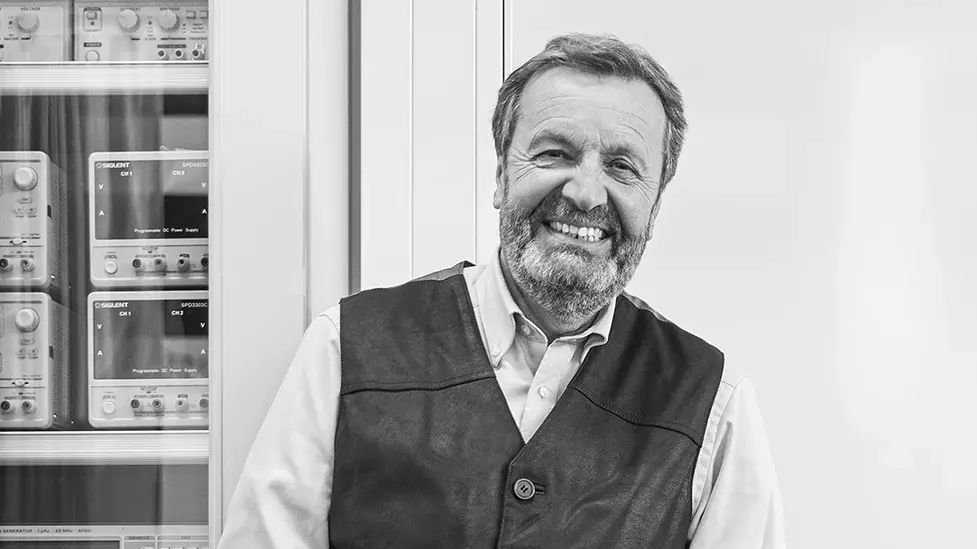 Ehemaliger der Hochschule RheinMain, Wilfried Kiegler Ehemaliger im Rentenalter lehnt an technischem Gerät seiner Studienzeit