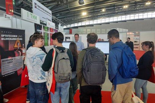 Junge Menschen an einem Messestand auf der Optatec in Frankfurt am Main