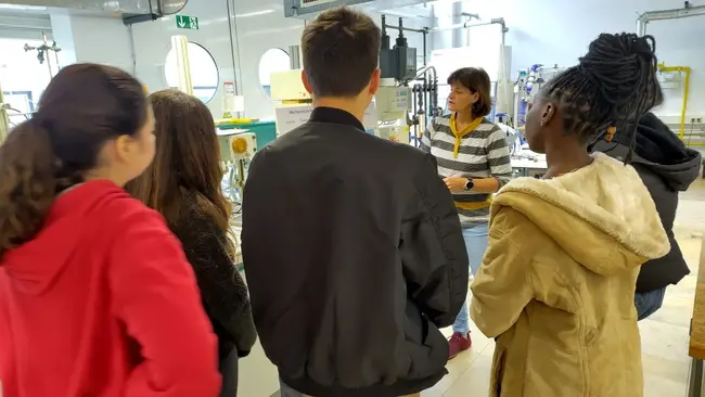 A group of students standing in a process engineering lab with a professor