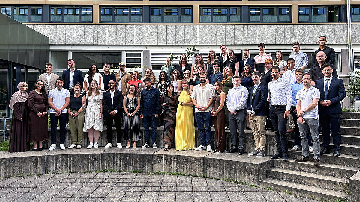Absolvent:innen der Hochschule RheinMain posieren für ein Gruppenfoto.