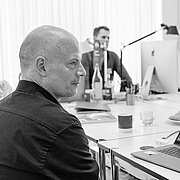Prof. Jörg Waldschütz sitzt während eines Arbeitstreffens des CCI-Instituts vor seinem Laptop. Im Hintergrund sind zwei weitere Personen zu sehen.
