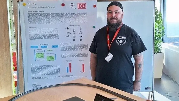 An einer Modelleisenbahnteststrecke zeigt Andreas Hellenbrand, wissenschaftlicher Mitarbeiter der Hochschule RheinMain, wie Daten mit Post-Quanten-Kryptografie sicher von den Sensoren am Gleisbett zur Monitoring-Zentrale übertragen werden können