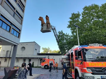 Zwei Dinos fahren hoch hinaus: Die Freiwillige Feuerwehr Rüsselsheim Stadt lädt auf ihre Drehleiter ein.