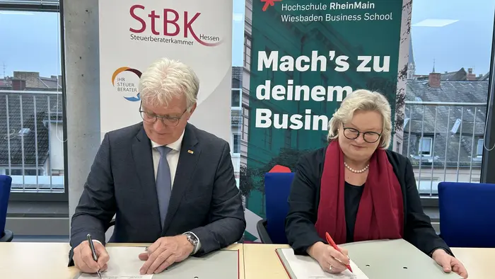 Hartmut Ruppricht, Präsident der Steuerberaterkammer (StBK) Hessen, und Prof. Dr. Eva Waller, Präsidentin der Hochschule RheinMain (HSRM), bei der Unterzeichnung des Kooperationsvertrags für den geplanten dualen Bachelorstudiengang Steuuerrecht.