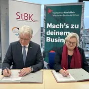 Hartmut Ruppricht, Präsident der Steuerberaterkammer (StBK) Hessen, und Prof. Dr. Eva Waller, Präsidentin der Hochschule RheinMain (HSRM), bei der Unterzeichnung des Kooperationsvertrags für den geplanten dualen Bachelorstudiengang Steuuerrecht.