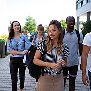 Fünf Studierende laufen über den Campus Rüsselsheim