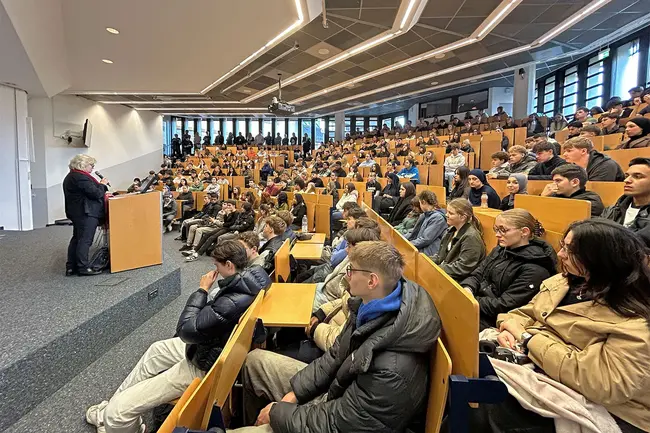 Hochschulpräsidentin Prof. Dr. Eva Waller steht auf der Bühne des Audimax und begrüßt die Schüler:innen zum Hochschulinformationstag 2025.