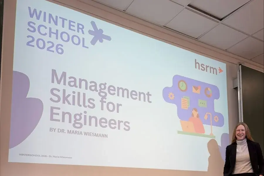 Ein Vortrag im Rahmen der "Winterschool 2026" mit dem Titel "Management Skills for Engineers" von Dr. Maria Wiesmann. Maria Wiesmann steht rechts neben der Präsentation an der Wand, die relevante Informationen für Ingenieure und deren Managementfähigkeiten bietet.