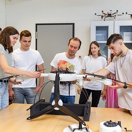 Studierende der Elektrotechnik mit einer Drohne